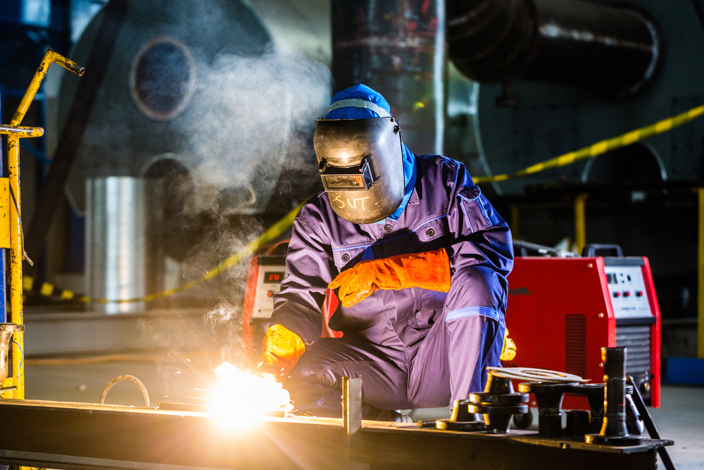 welder working with a MIG welding machine in proper safety wear